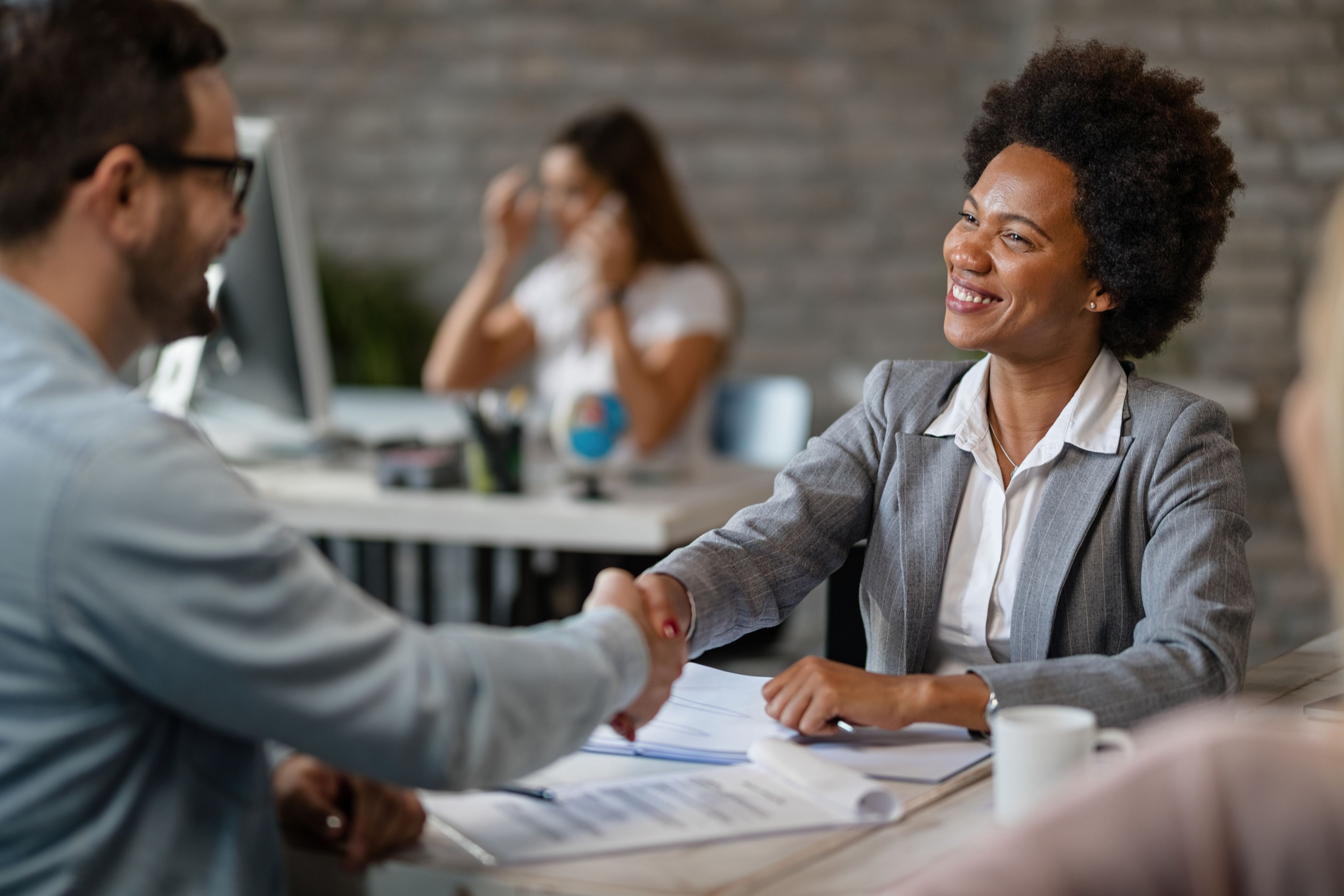 happy-african-american-bank-manager-shaking-hands-with-client-after-successful-agreement-office (1)